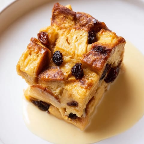 Warm, delicious bread pudding bursting with juicy raisins and a sweet vanilla-infused custard flavor.