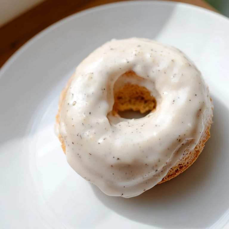 Perfectly golden muffin tin donuts, smelling of vanilla, sit cooling before being dipped in glaze.