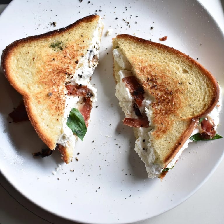 A skillet-ready Crispy Prosciutto & Burrata Grilled Cheese sandwich with crispy prosciutto and oozing burrata.