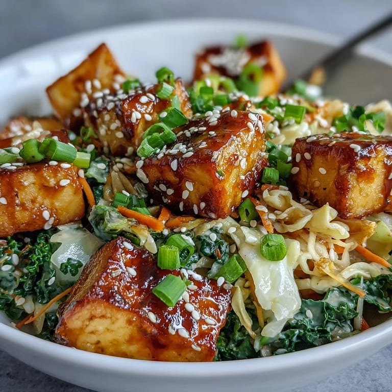 A fork lifts savory tofu and cabbage from this easy Tofu Egg Roll in a Bowl.